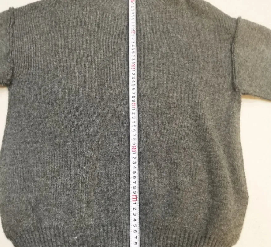 Women's dark grey acrylic knitted lounge suit with side-slit sweater and matching trousers on a hanger.