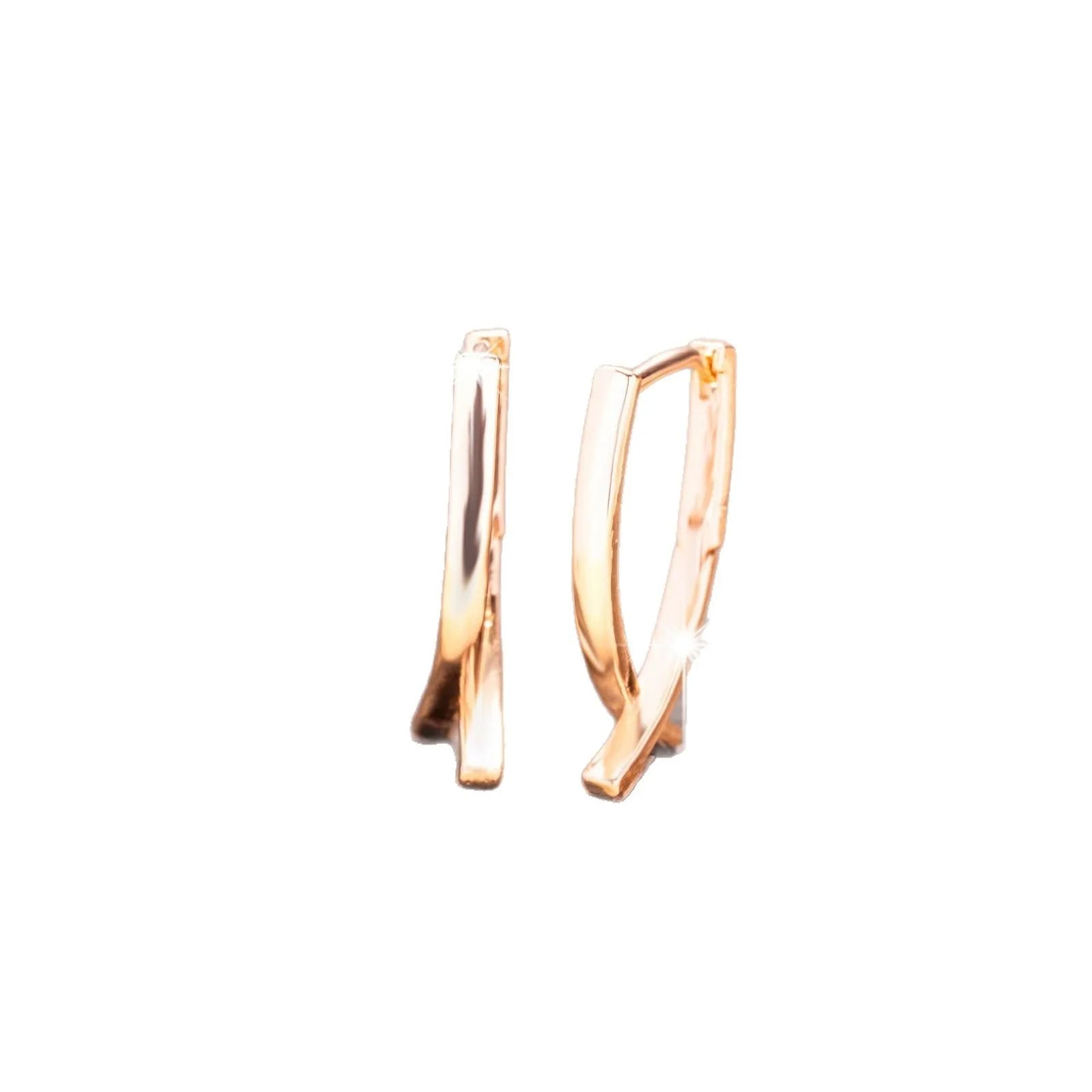 A pair of rose gold coloured cross shaped earrings on a copper base.