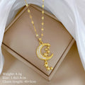 Geometric moon pendant necklace with crystals and tassel detail on an adjustable stainless steel chain.