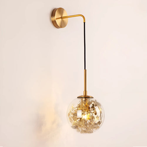 Modern golden flower glass wall lamp mounted beside a bed.