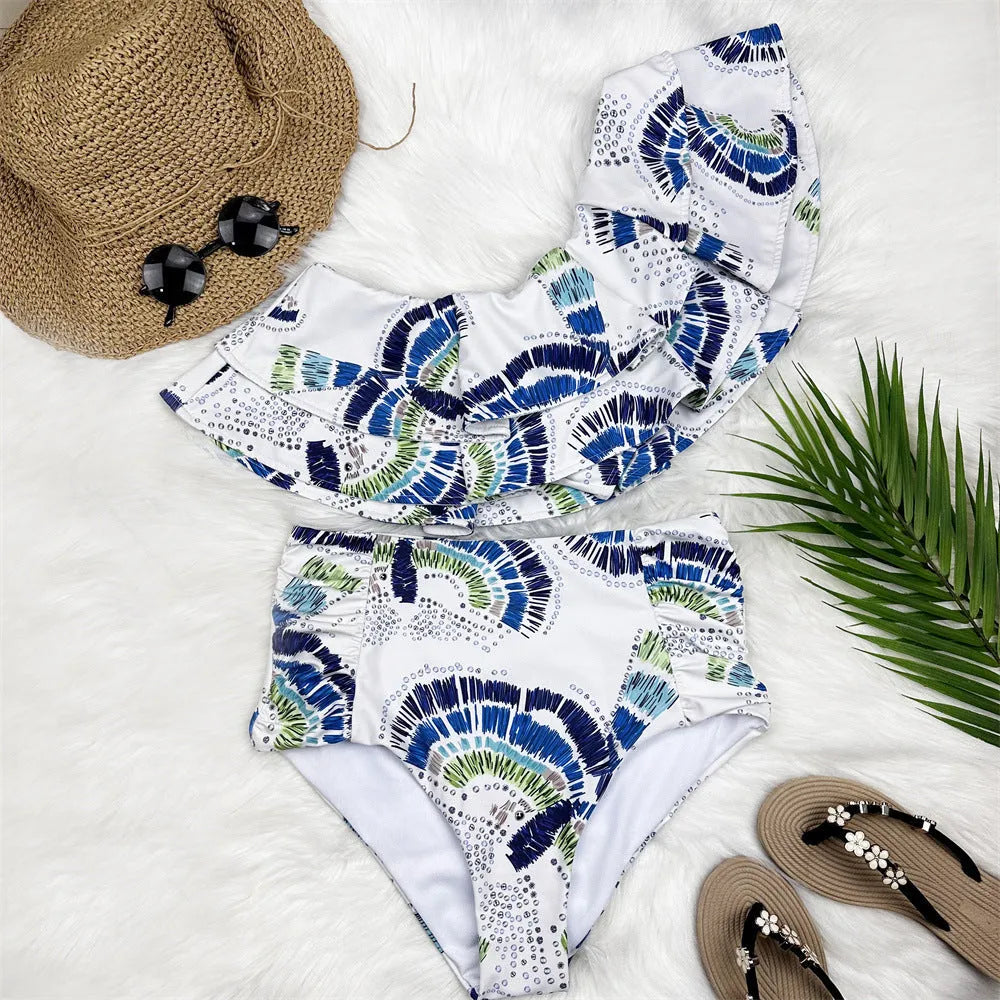 White one-shoulder women's swimsuit with a large layered lotus leaf skirt and split-leg design.
