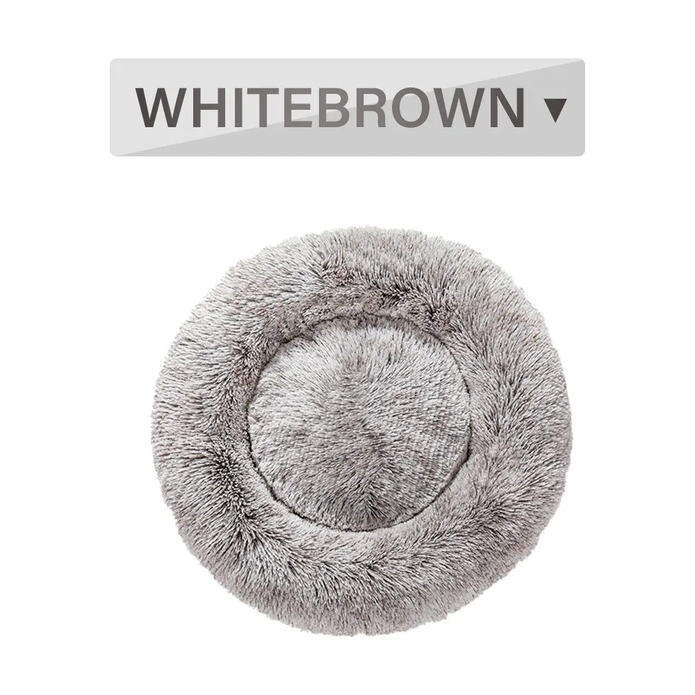 Fluffy grey donut-shaped dog bed with high plush sides on a wooden floor.