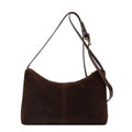 Retro brown suede underarm bucket bag with visible sewing line detail on a woman's shoulder during commute