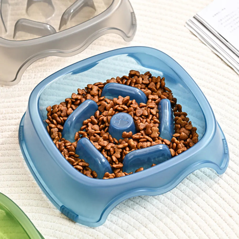 Blue plastic slow-feed dog bowl on a floor to prevent choking.