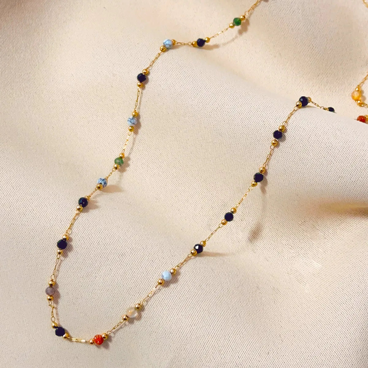Gold coloured titanium steel necklace with an O-ring chain and a natural stone pendant.