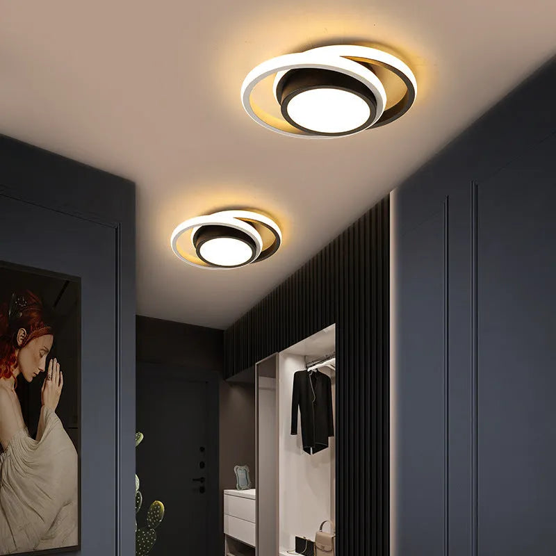 Modern round aluminium ceiling light with integrated LEDs, shown illuminating an entrance hall.