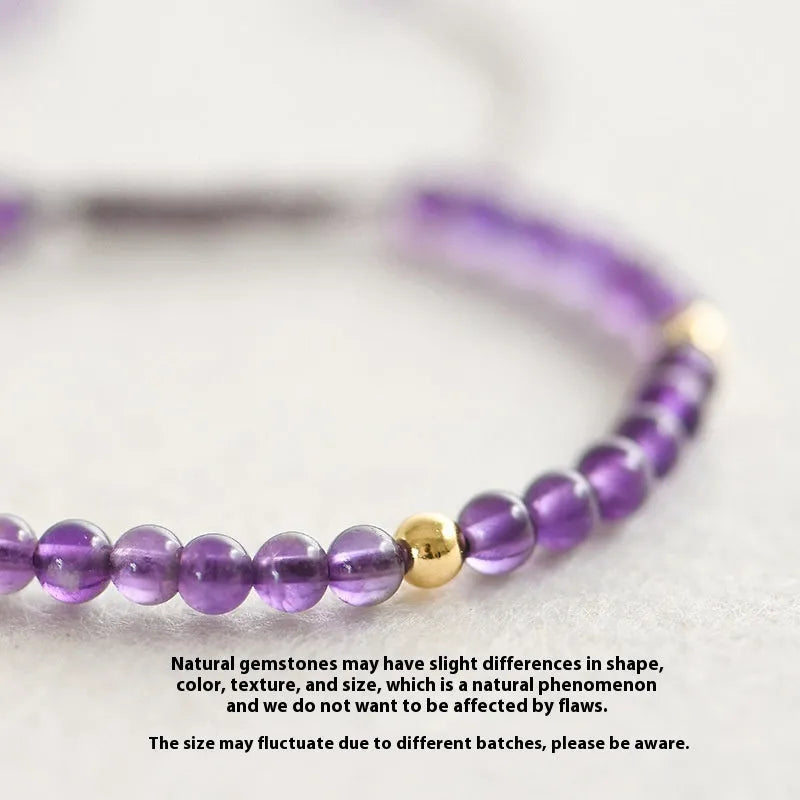 Handmade purple amethyst and 14K gold bracelet with 4mm round beads on a wrist.