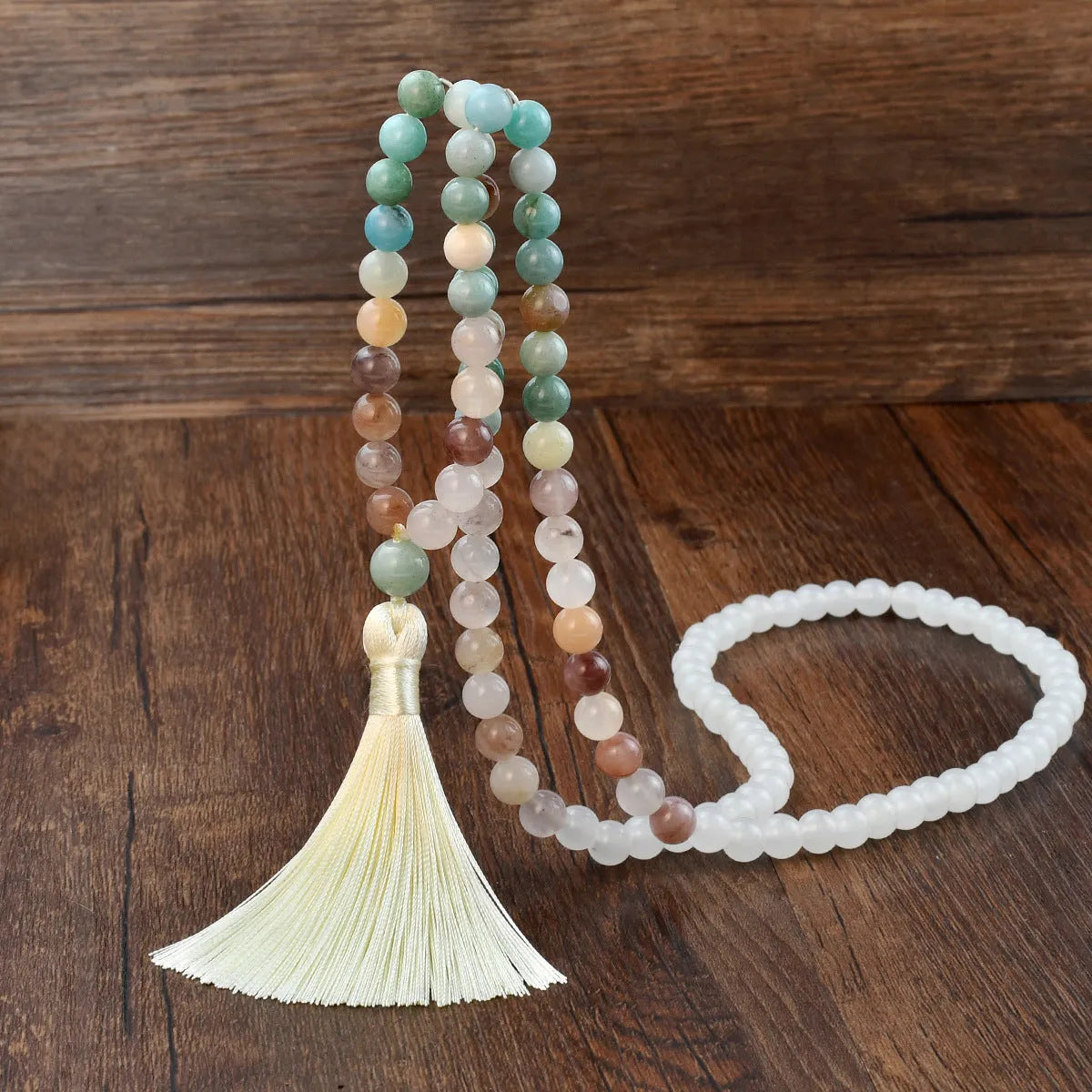 A long bohemian-style necklace with a geometric mixed gemstone pendant and a coloured tassel on a ball bead chain.