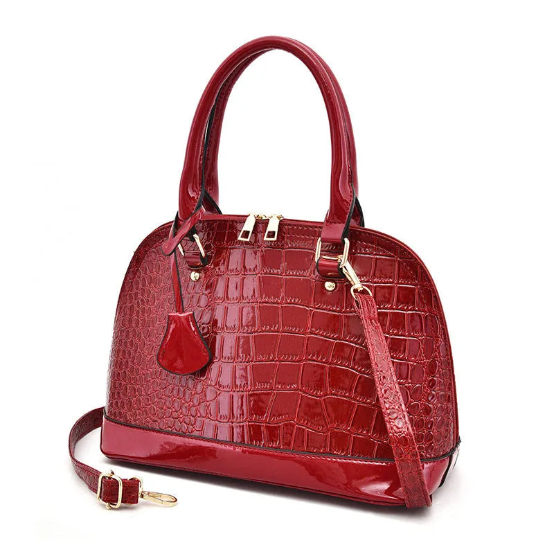 Shiny PU crossbody bag with shell shape, shown in black, red, or brown colour options