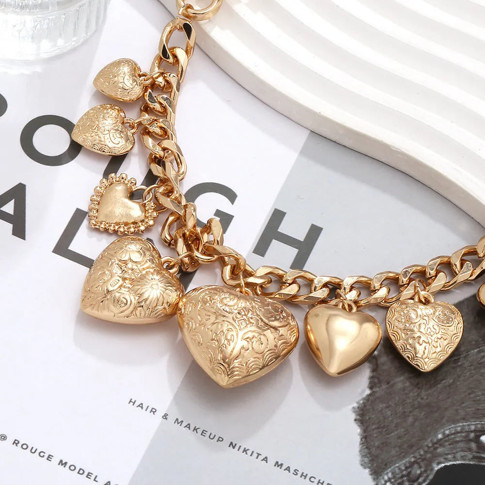 Gold exaggerated carved heart pendant necklace on model, showing adjustable metal chain.