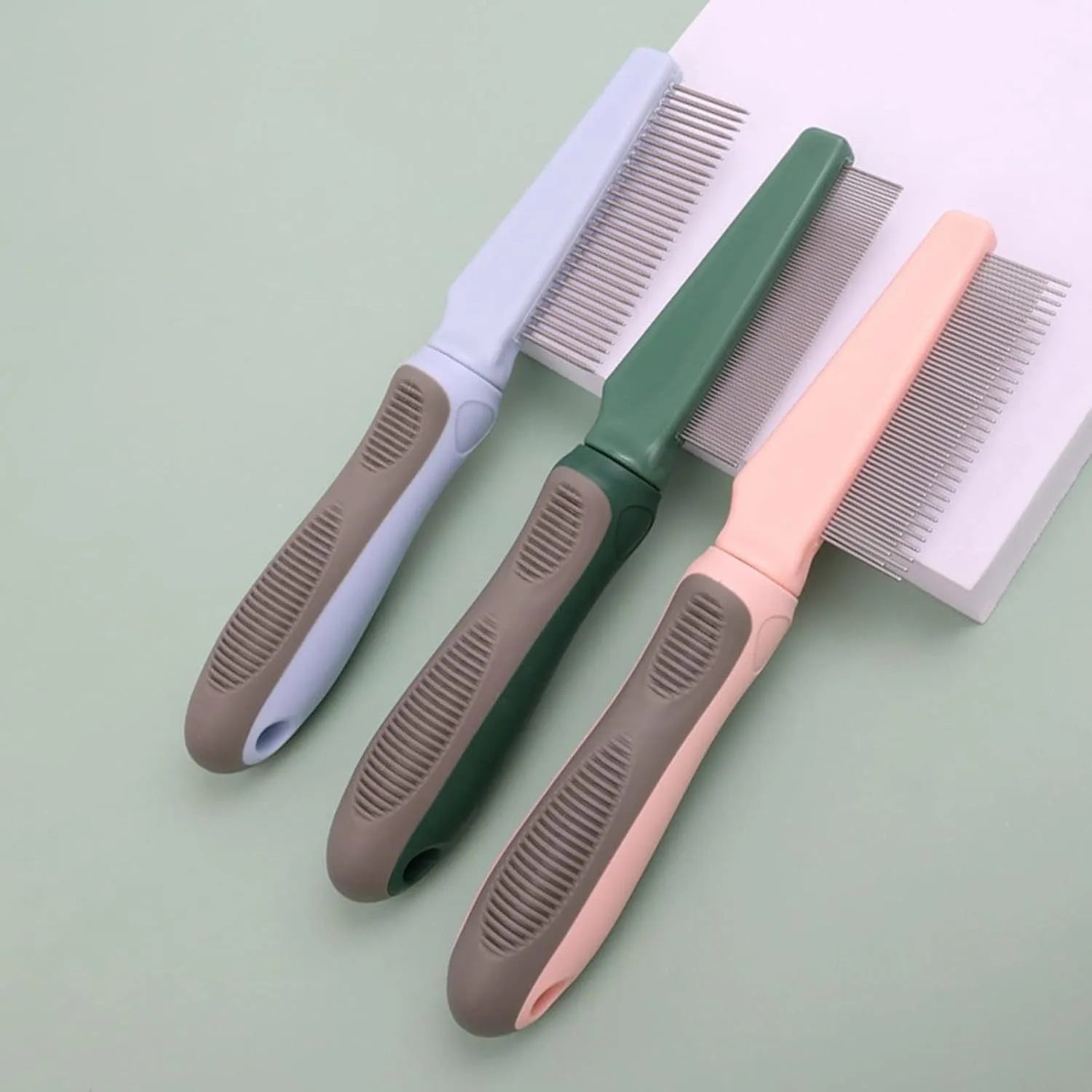 Blue pet detangler comb with rubber handle showing three comb teeth configurations