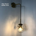Modern golden flower glass wall lamp mounted beside a bed.