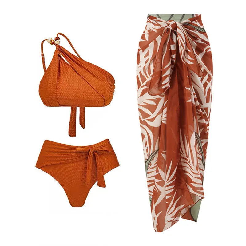 Women's brown push up high waist swimsuit with a split brief design and a sheer black chiffon dress overlay.