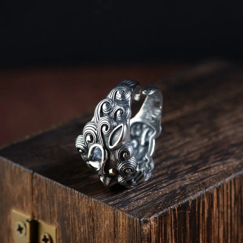 Silver open-ended ring with a raised Domineering Jibeast animal zodiac pattern.