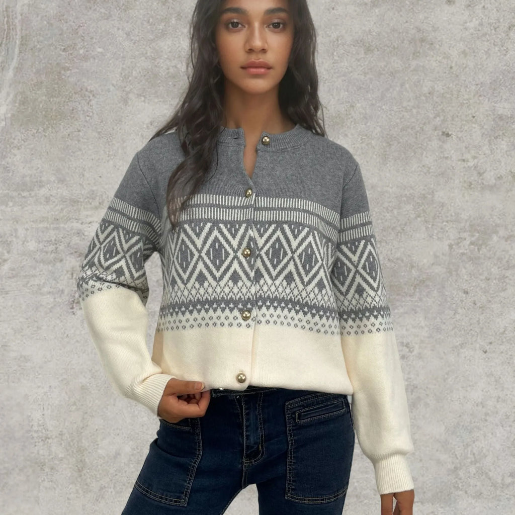 Woman wearing a grey alpaca wool cardigan with a long-sleeve diamond knit pattern in contrasting colours.