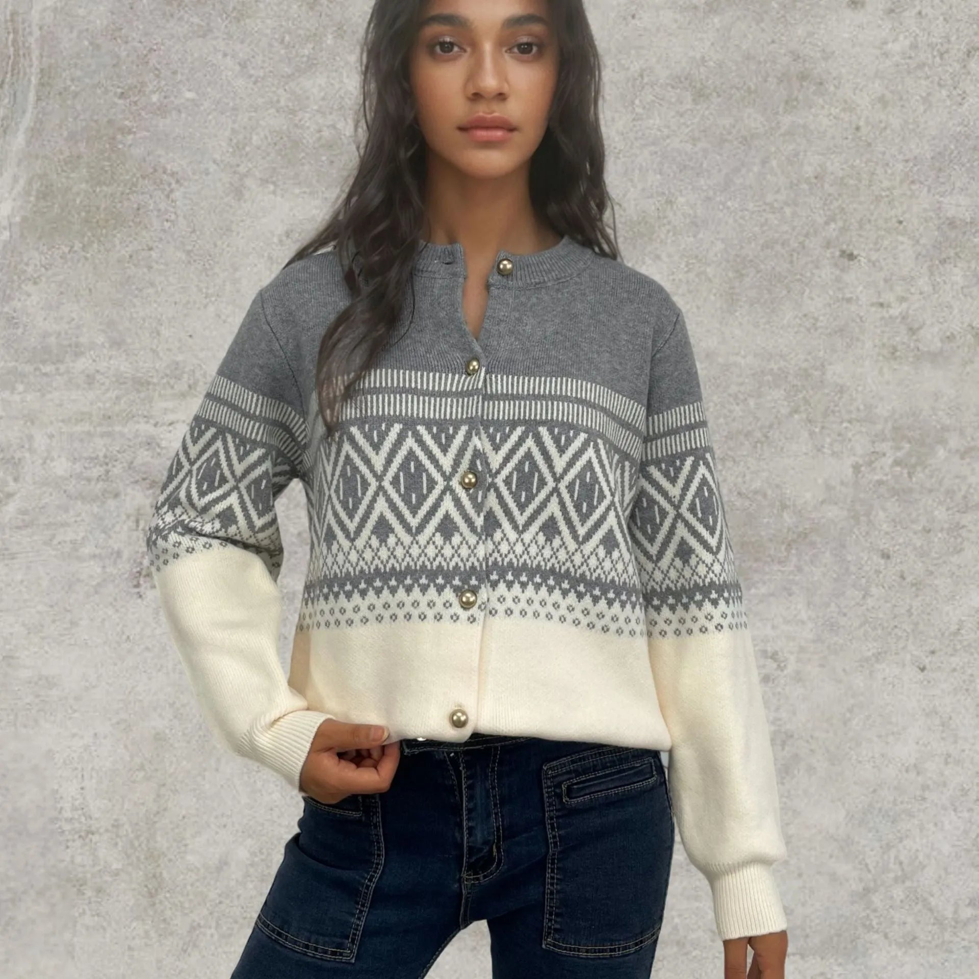 Woman wearing a grey alpaca wool cardigan with a long-sleeve diamond knit pattern in contrasting colours.