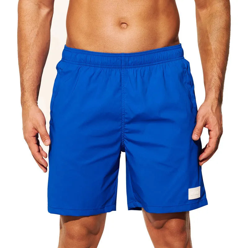 Men's solid colour quick-drying nylon sports shorts on a man, showing straight leg opening.