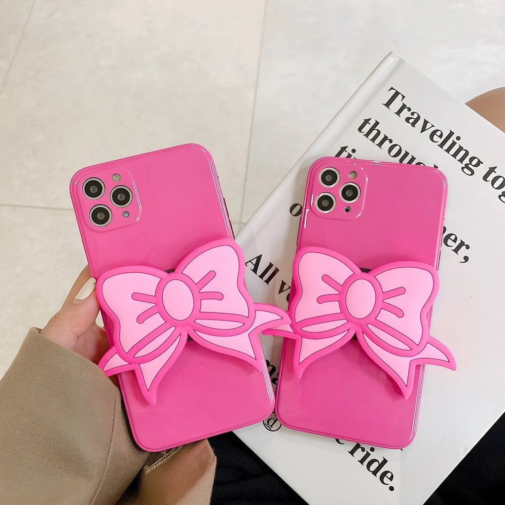 Rose red iPhone case with a large pink bow and a folded-out kickstand on the back.