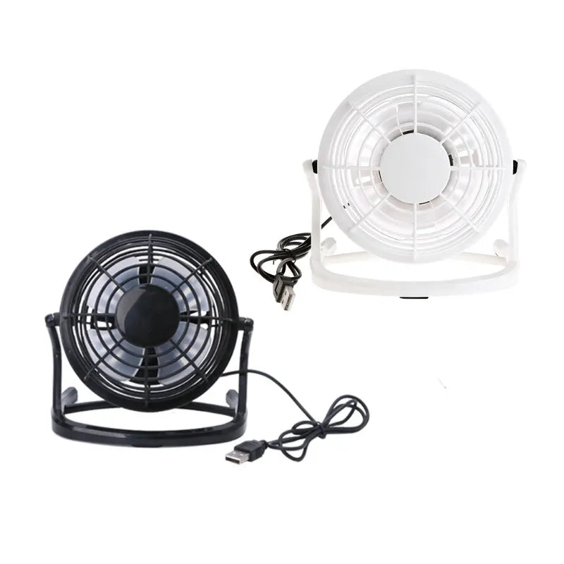 Small black and white USB desk fan with adjustable angle on a wooden table.