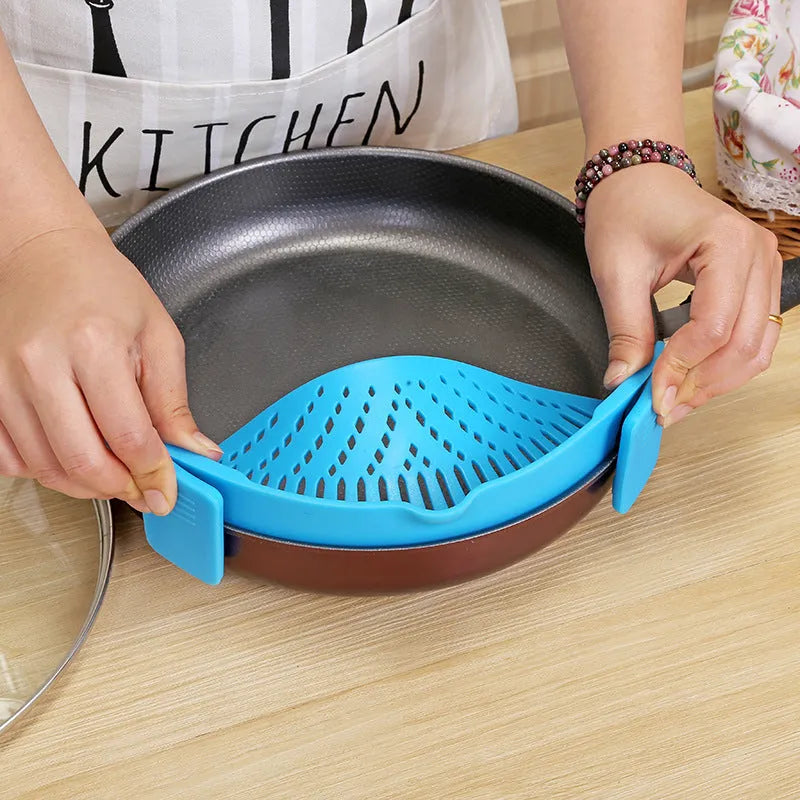 Silicone clip-on funnel strainer attached to a pot rim for draining liquids.