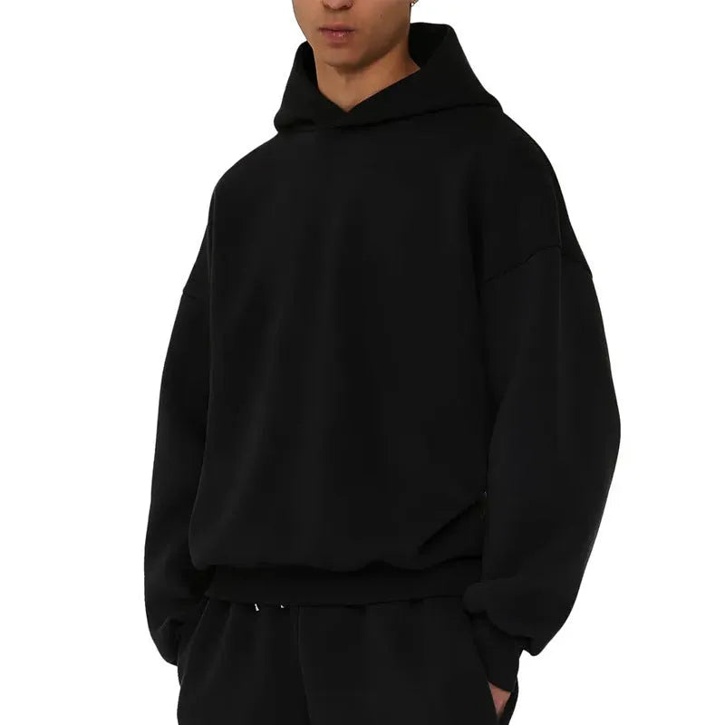 A man's solid-colour fleece-lined cotton hoodie with a wool interior, shown in a casual setting.