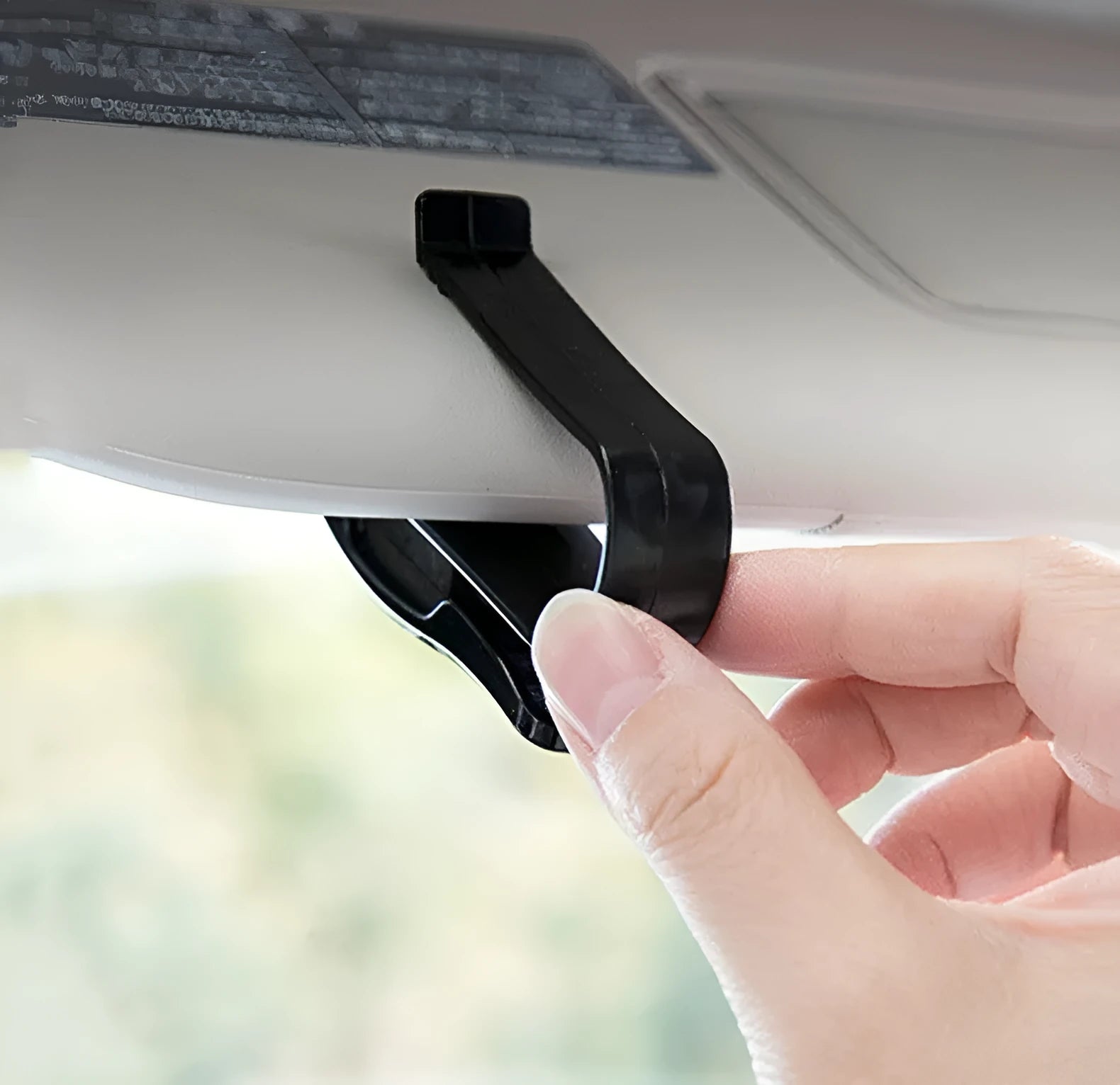 Black plastic multifunctional clip for car sun visors to hold tickets, IDs, or glasses.