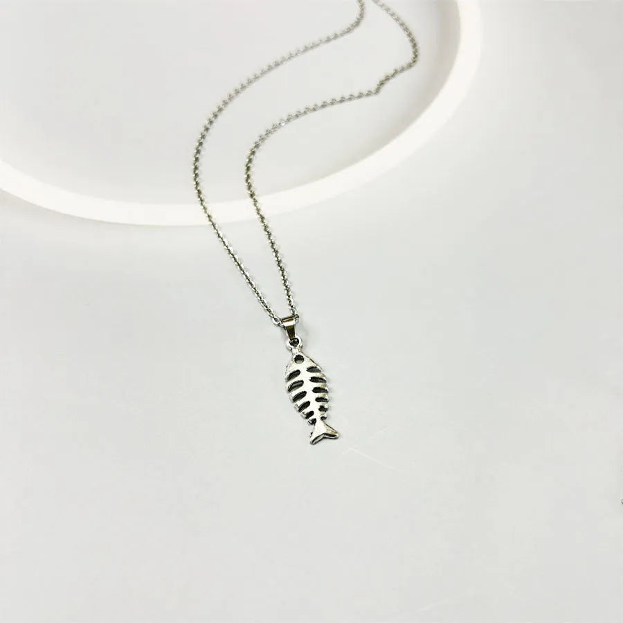 Fishbone pendant necklace and matching earrings set with adjustable chain on grey background