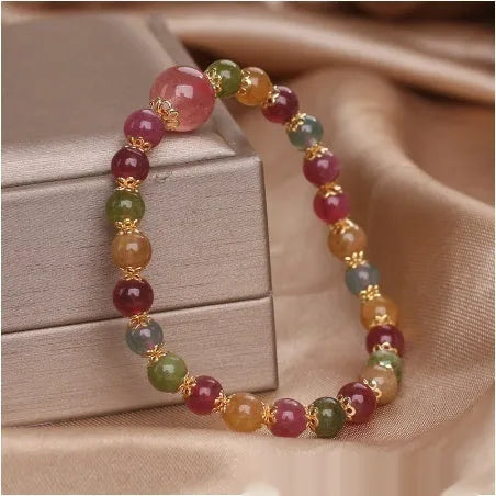Close-up of a beaded bracelet with round strawberry quartz and tourmaline stones, 10mm in size.