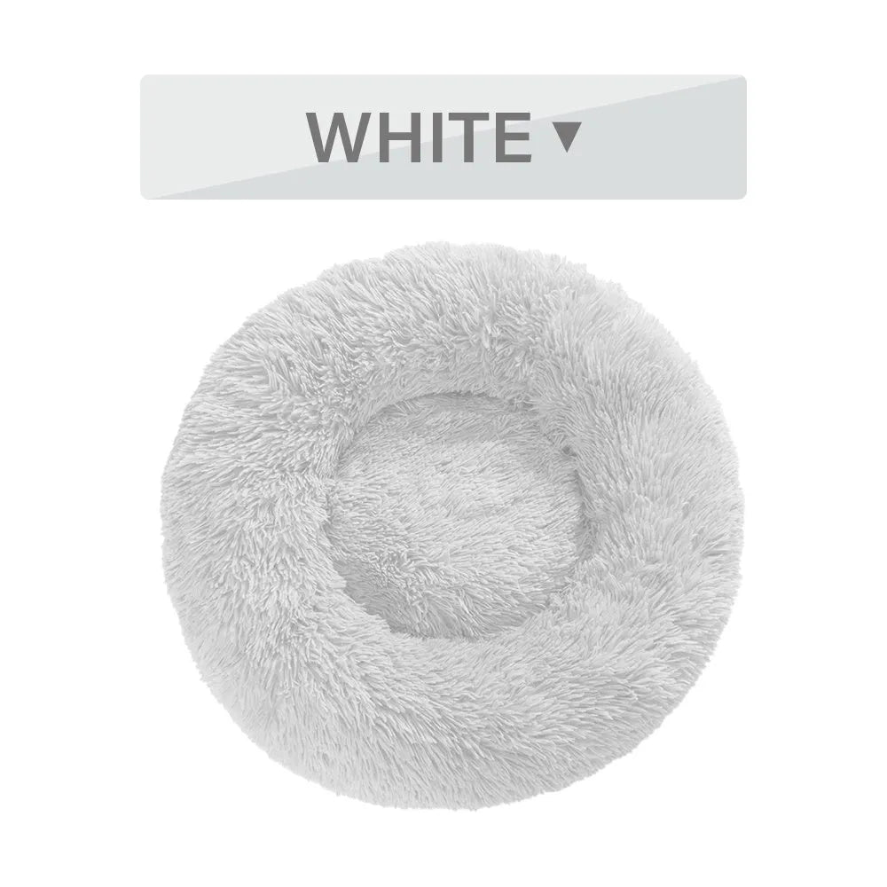 Fluffy grey donut-shaped dog bed with high plush sides on a wooden floor.