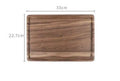 Black walnut wood cutting board set showing rectangular and round boards with juice grooves and side handles