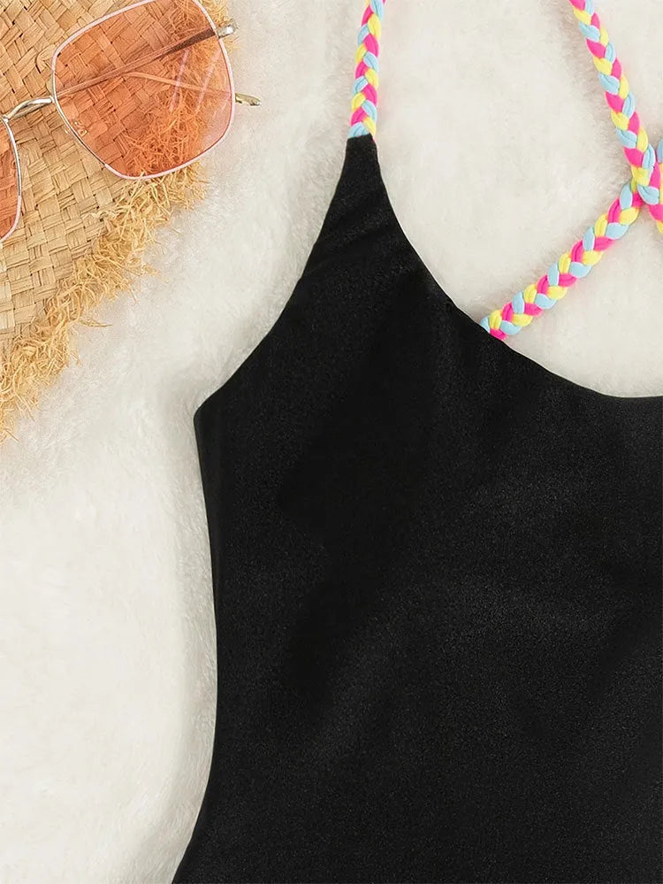 Black backless one-piece swimsuit for women on a mannequin, sleeveless design.