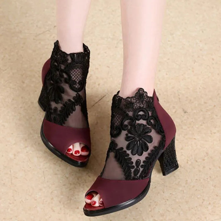 Black women's gladiator sandals with flower lace upper, square heel, and back zip closure.