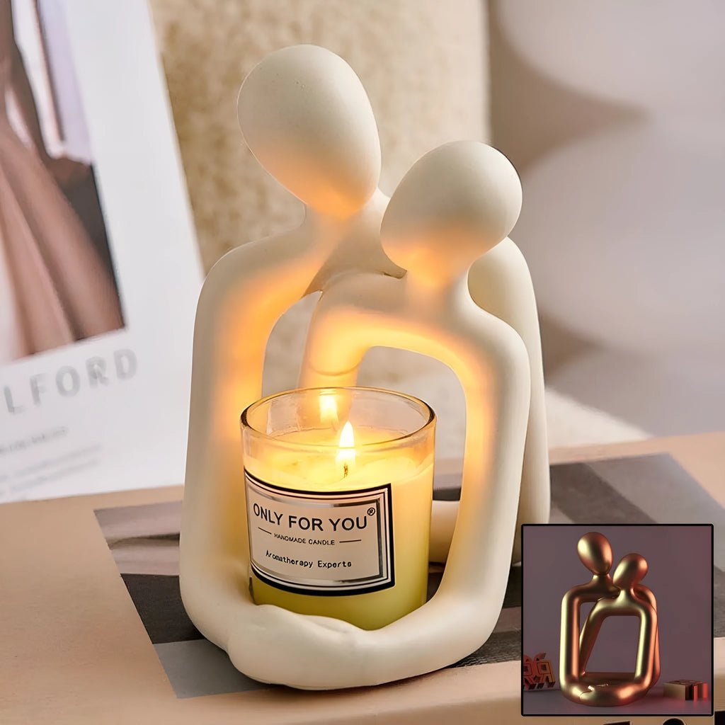 Modern resin couple statue in milky white or gold colour on a wooden surface.