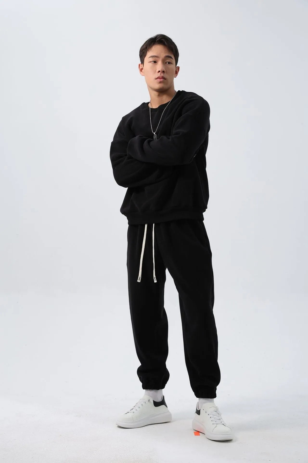 Man wearing a loose black polar fleece winter sports suit with crew neck coat and trousers