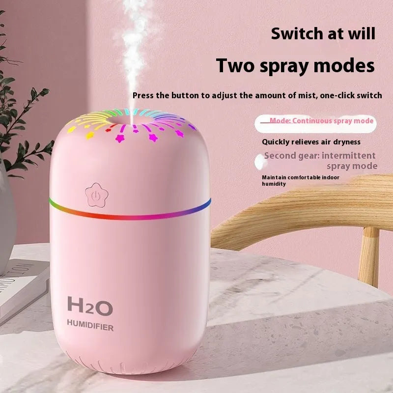 Compact white USB-powered mini humidifier with water tank on a wooden desk.