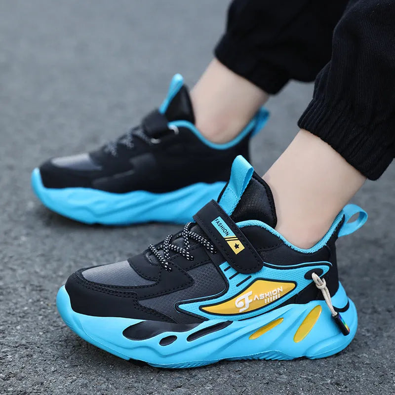 Boy's blue sports running shoe with velcro strap and mesh upper on a hard ground surface.