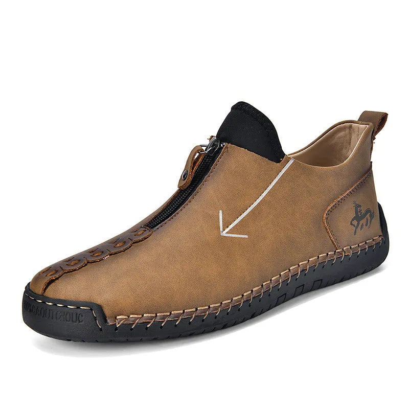 Men's black leather ankle boots with a front zip and hand-stitched detailing on a rubber sole.