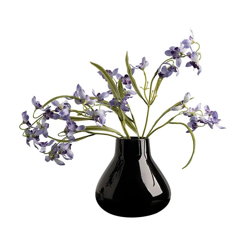 Modern ceramic vase with two white artificial orchid stems in minimalist home setting