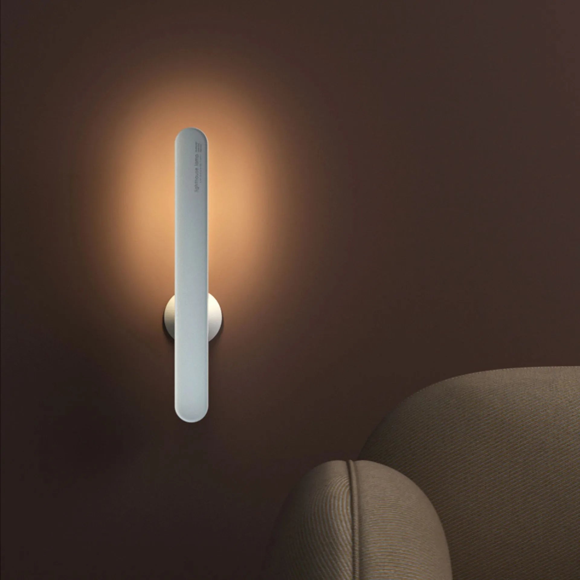 White geometric desk lamp with magnetic base mounted on a metal wall surface.