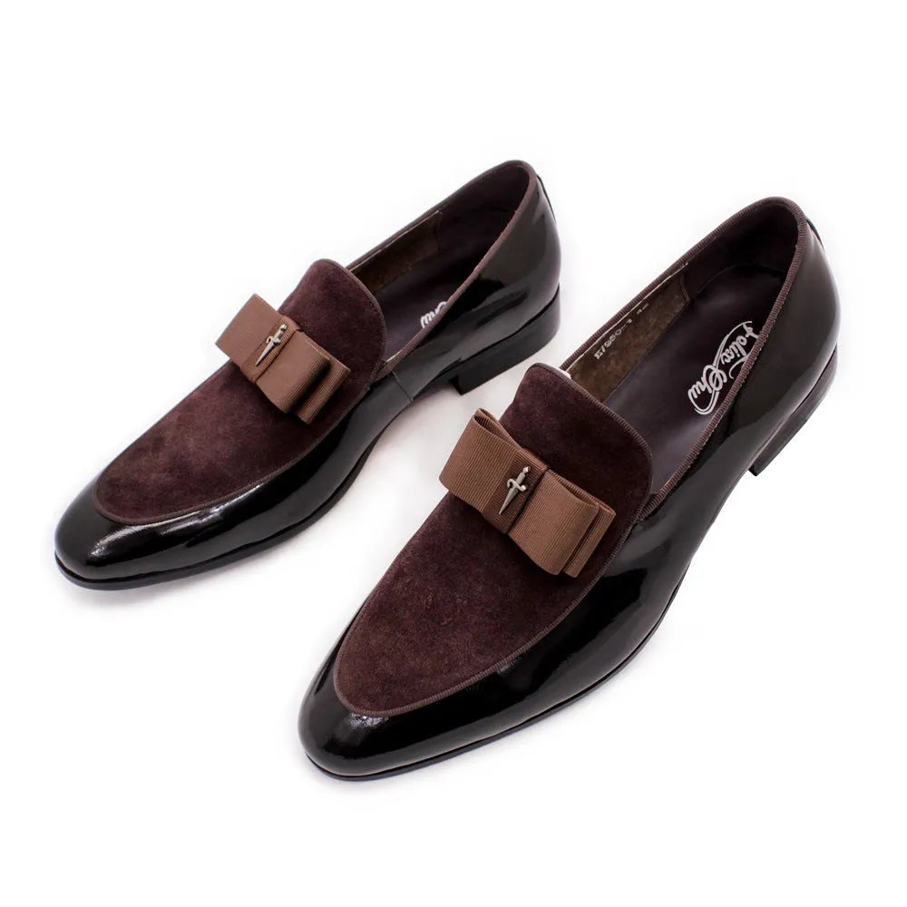 Men's black and brown tassel loafers with a matte and patent leather upper on a wooden floor.