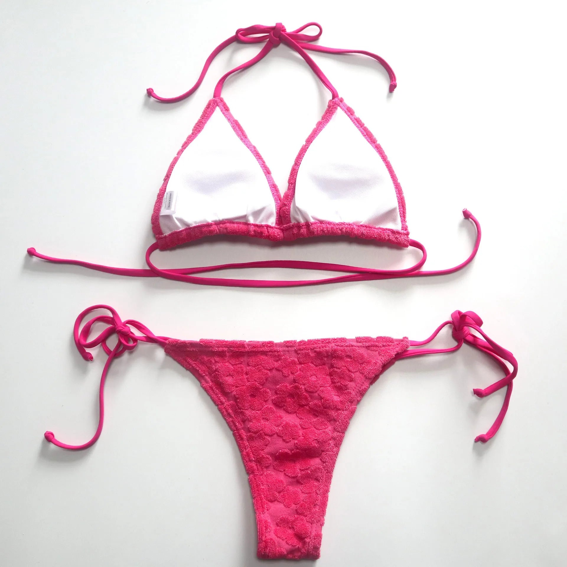 Women's bikini swimsuit with a lace-up back in flower fabric, shown in rose red and blue.