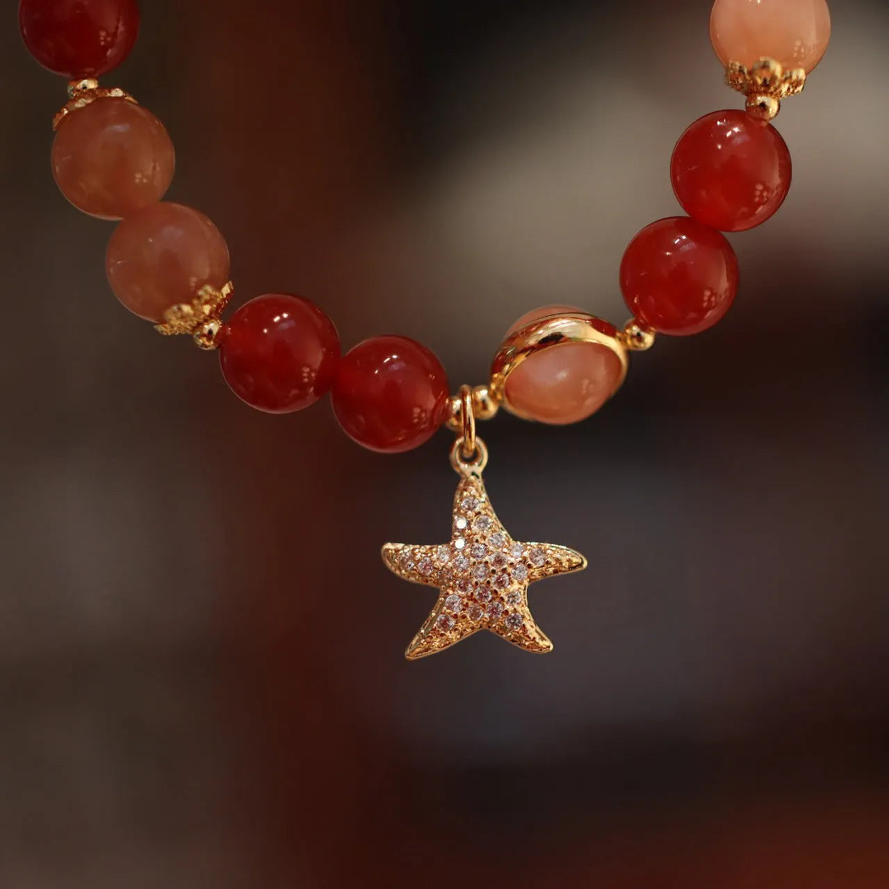 Handmade red agate and orange sunstone bracelet with star and cloud motifs