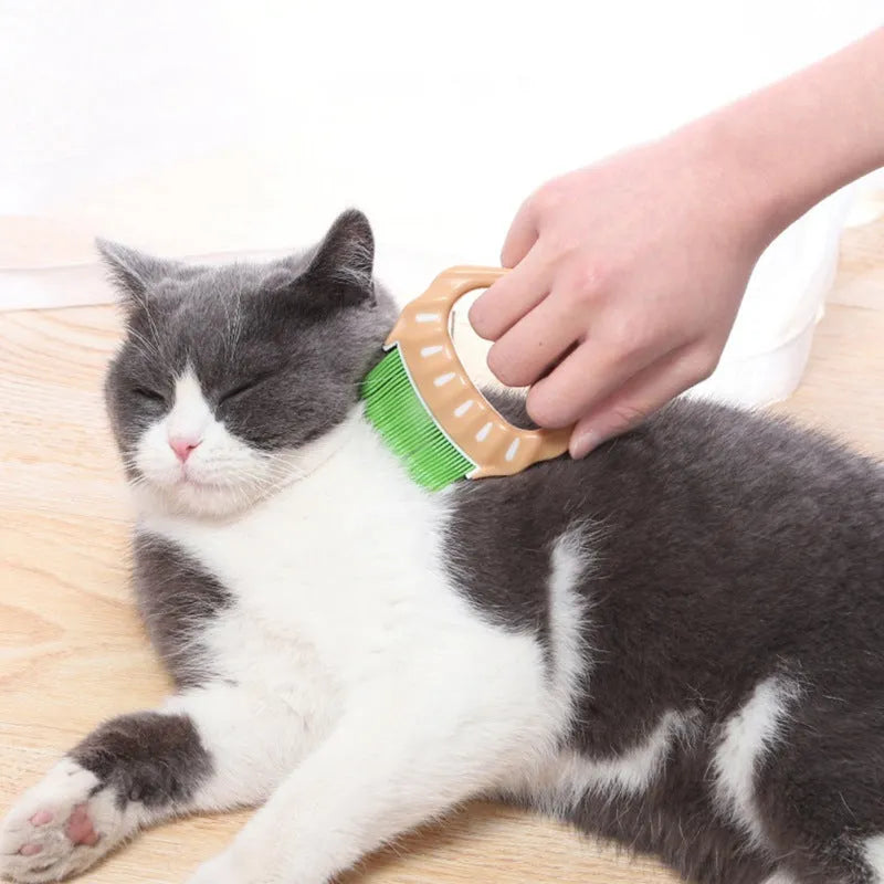 Green shell-shaped pet grooming comb with bent wire bristles and an anti-slip plastic handle.