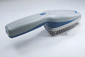 White pet ion comb with removable brush head and 78 comb teeth on a blue background.