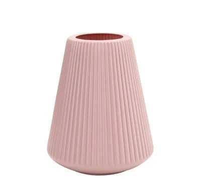 Colourful melamine plastic flower vase in blue, green, pink, or white on a desk.