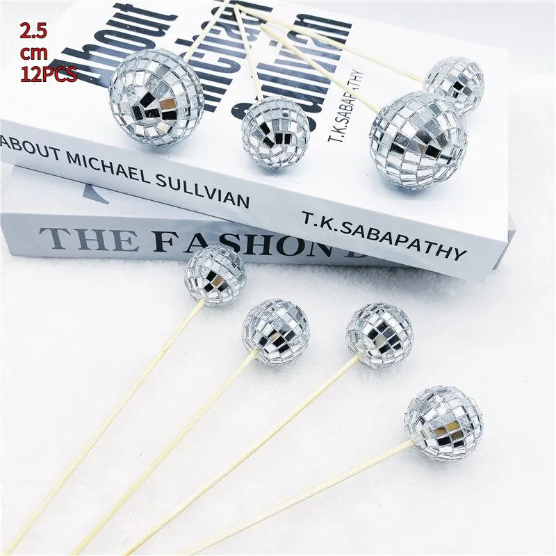 Small glass mirrored disco ball cake decoration attached to a thin wooden stick.