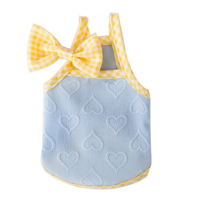 Small dog wearing a blue elastic vest with heart texture and bow suspenders.