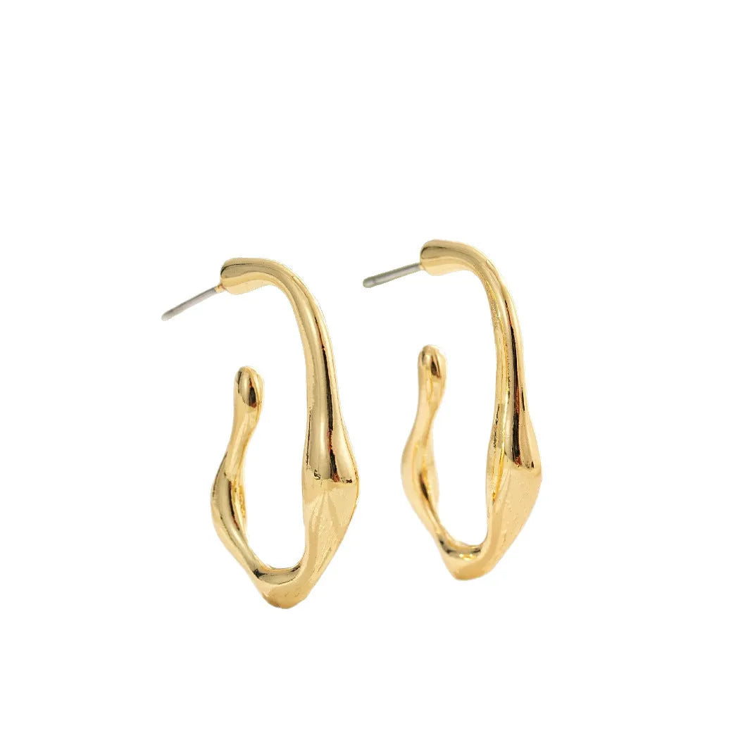 Gold irregular shaped minimalist earrings for women with a geometric silhouette on a plain background.