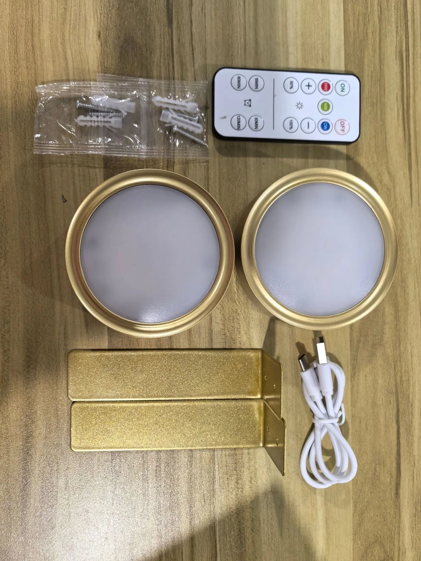 Black magnetic wireless LED lamp with remote control mounted next to a painting on a wall.