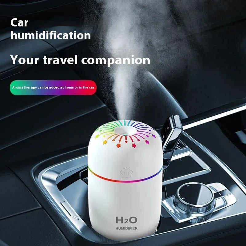 Compact white USB-powered mini humidifier with water tank on a wooden desk.